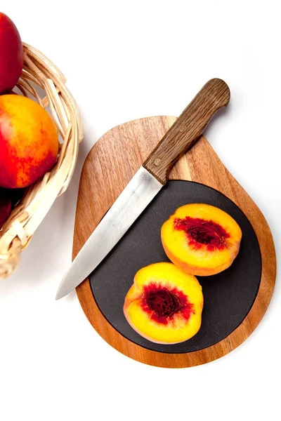 Bıçak ile ahşap kesme tahtası üzerinde taze yıkanmış şeftali