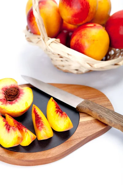 Bıçak ile ahşap kesme tahtası üzerinde taze yıkanmış şeftali