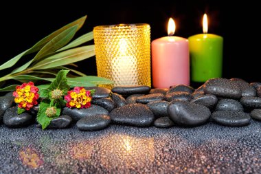 Spa dekorasyon taşları ve siyah bir zemin üzerine mum