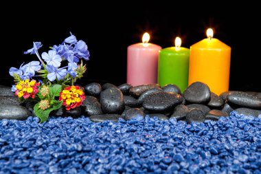 Spa dekorasyon taşları ve siyah bir zemin üzerine mum