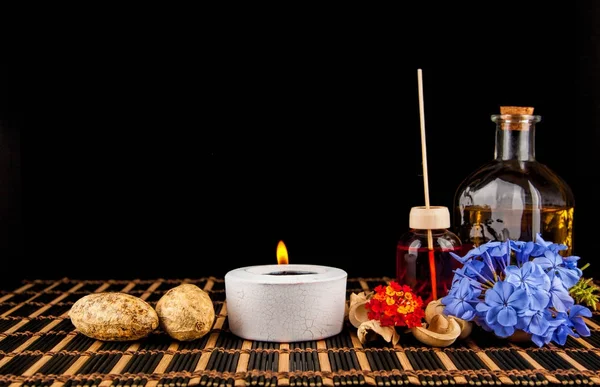 Decorazione Spa con pietre, candela, con olio da massaggio su un blac Foto Stock