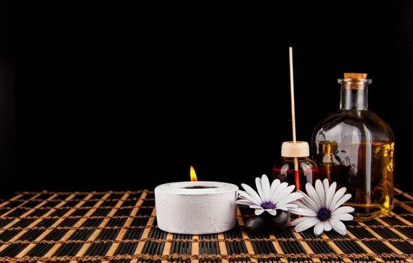 Decorazione Spa con pietre, candela, con olio da massaggio su un blac Fotografia Stock