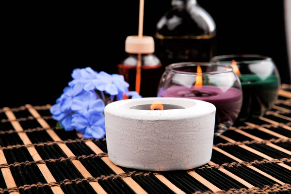 Tema de spa com velas e flores em fundo preto — Fotografia de Stock