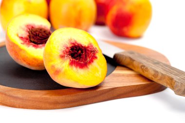 Bıçak ile ahşap kesme tahtası üzerinde taze yıkanmış şeftali