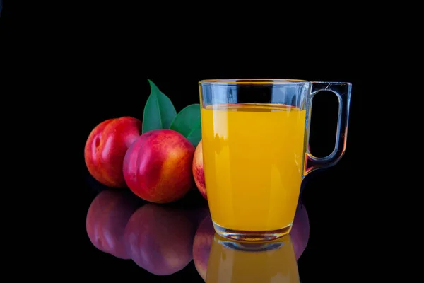 Персиковый сок в стакане на черном фоне — стоковое фото
