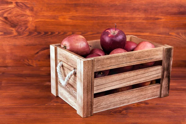 Manzanas rojas frescas y deliciosas en una caja de madera en un bac blanco — Foto de Stock