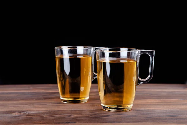 Two glasses of apple juice on a black background — Stock Photo, Image