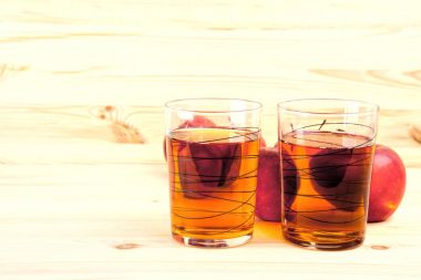 iki bardak suyu ve ahşap arka plan üzerinde kırmızı elmalar