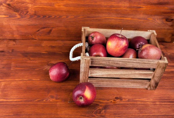 Vers en lekker rode appels in een houten kist op een witte bac — Stockfoto