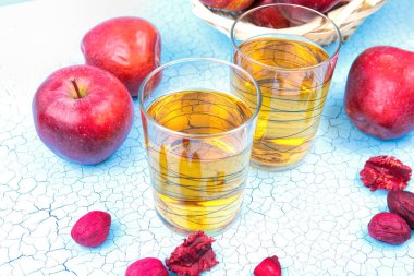 Bardak elma suyu ve mavi eski ahşap backg üzerinde kırmızı bir elma