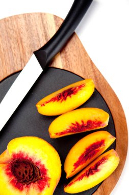 Bıçak ile ahşap kesme tahtası üzerinde taze yıkanmış şeftali