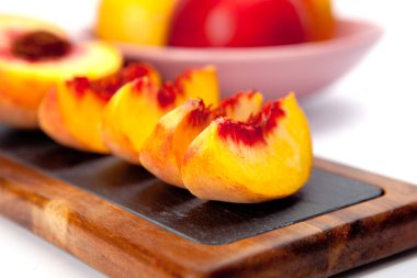 Şeftali bir kesme tahtası üzerinde parçaları