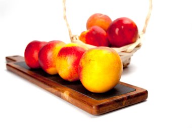 Beyaz izole ahşap kesme tahtası üzerinde taze yıkanmış şeftali 