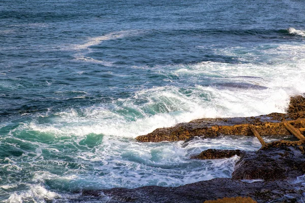 Onde marine che si infrangono contro le rocce . — Foto Stock