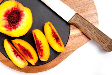 Bıçak ile ahşap kesme tahtası üzerinde taze yıkanmış şeftali