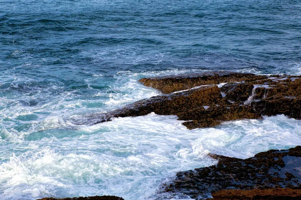 Onde marine che si infrangono contro le rocce . — Foto Stock