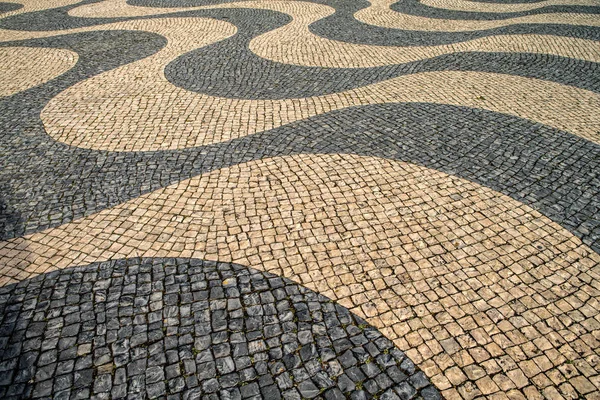 Typiska portugisiska kullerstensbelagda trottoaren mönster. svart och whit — Stockfoto