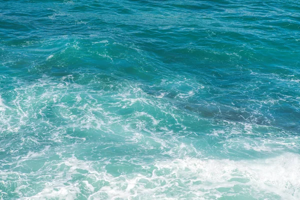 Salpicaduras de agua de mar con olas espumosas. Textura de superficie de agua . — Foto de Stock