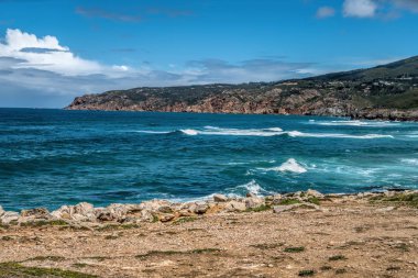 Dalgalar deniz kayalık sahil karşı güneşli yaz gününde dövüyorsun