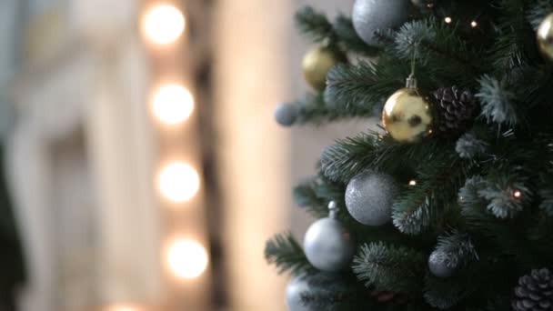 Рождественская елка с игрушками на фоне огней — стоковое видео
