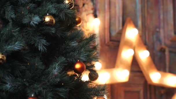 Різдвяна ялинка з іграшками на фоні світлої зірки — стокове відео