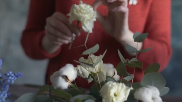 Fleuriste fille mains gros plan faire une composition de fleurs — Video