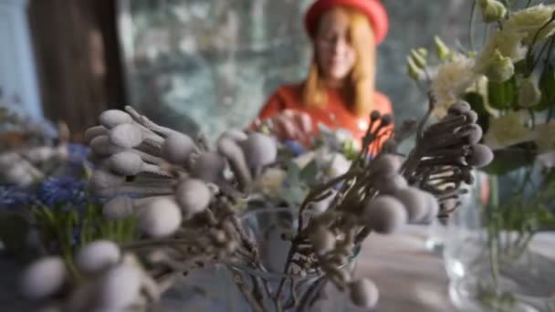 Fleurs sur fond flou fleuriste fille faisant une composition de fleurs — Video