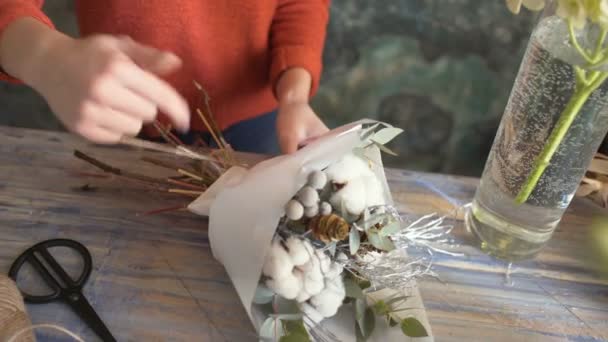 Fleuriste fille mains gros plan faire une composition de fleurs — Video