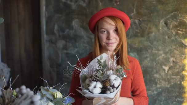 Florista chica sonrisa y muestra una composición de flores — Vídeos de Stock