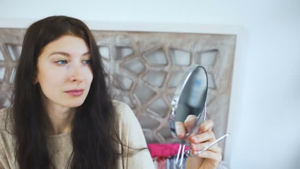 Mooie jonge vrouw met een spiegel en lach zelf - make-up concepten — Stockvideo