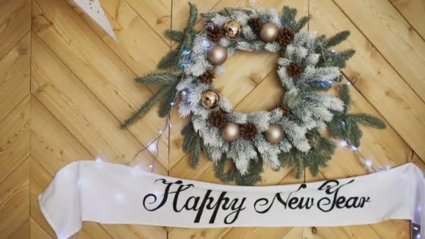 Feliz año nuevo signo en el fondo de la corona del árbol de Navidad — Vídeo de stock