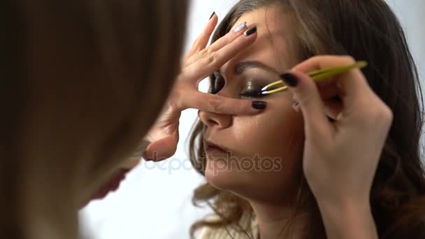 Визажист делает девушке красивый макияж для глаз перед важным событием — стоковое видео
