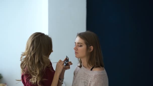 Maquillaje artista hace una chica hermosa maquillaje para los ojos antes de un evento importante — Vídeo de stock