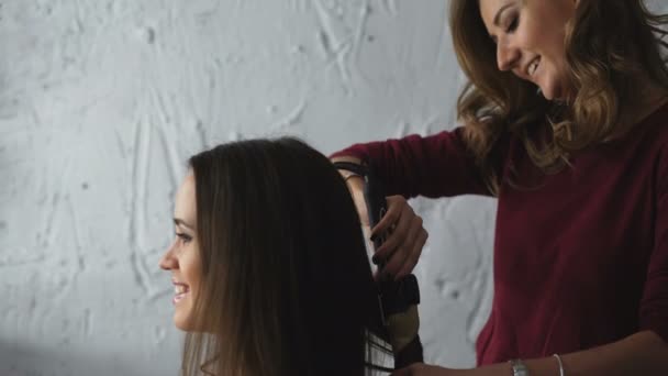 Make-up artist makes a girl beautiful hairstyle before an important event — Stock Video