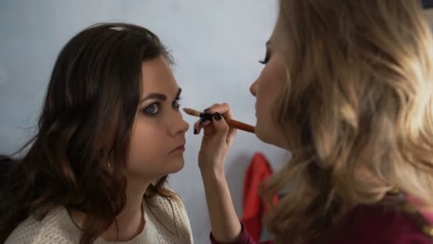 Make-up artist κάνει μια κοπέλα όμορφη μακιγιάζ για τα μάτια πριν από ένα σημαντικό γεγονός — Αρχείο Βίντεο