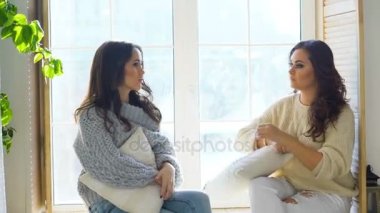 İki güzel kız camda otururken tartışmak. Kız eğlence ve kahkaha yatak odasında.
