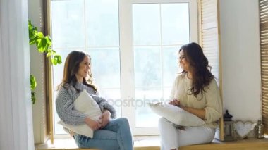 İki güzel kız camda otururken tartışmak. Kız eğlence ve kahkaha yatak odasında.