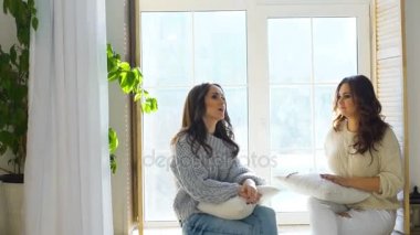 İki güzel kız camda otururken tartışmak. Kız eğlence ve kahkaha yatak odasında.