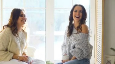 İki güzel kız camda otururken tartışmak. Kız eğlence ve kahkaha yatak odasında.
