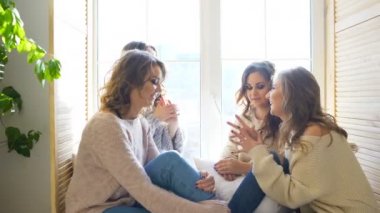 dört güzel kız camda oturan gülümseme tartışmak. Kız eğlence ve kahkaha yatak odasında