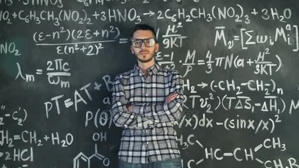 Joven científico posando en ecuaciones químicas y matemáticas habitación de la pared interior — Vídeos de Stock