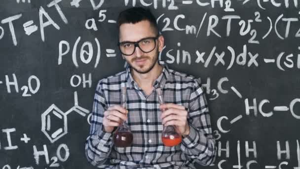 Молодий науковець проводить лабораторний експеримент в хіміко математичних рівняннях настінної кімнати — стокове відео