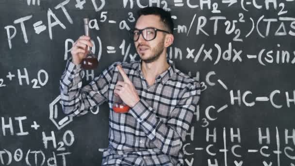 Genç bilim adamı adam olun kimyasal deney Laboratuvarı ve Matematiksel denklemler oda duvar — Stok video