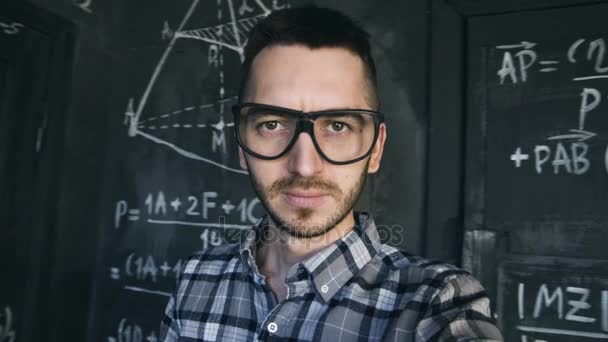 Joven científico hombre hacer selfie disparar en química y matemática ecuaciones pared habitación interior — Vídeos de Stock