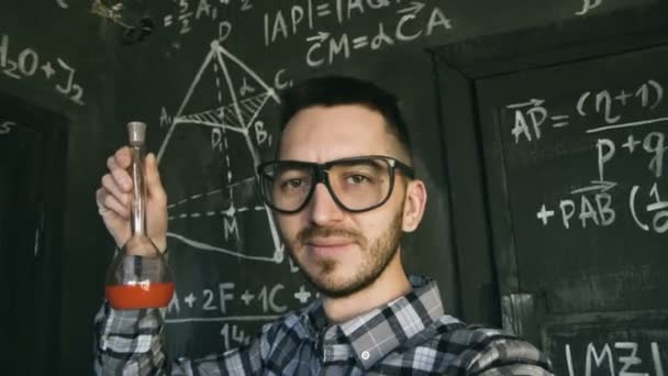 Молодой ученый делает селфи съемки в интерьере комнаты химических и математических уравнений — стоковое видео