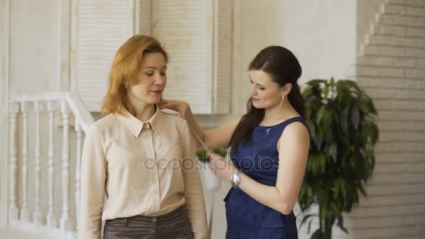 Young clother designer woman shows the cloth to her client in tailor studio — Stock Video