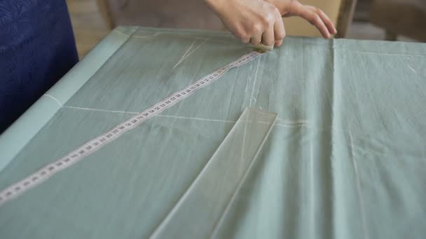 Seamstress and fashion designer at work. Young woman draw chock on the cloth in tailor studio — Stock Video