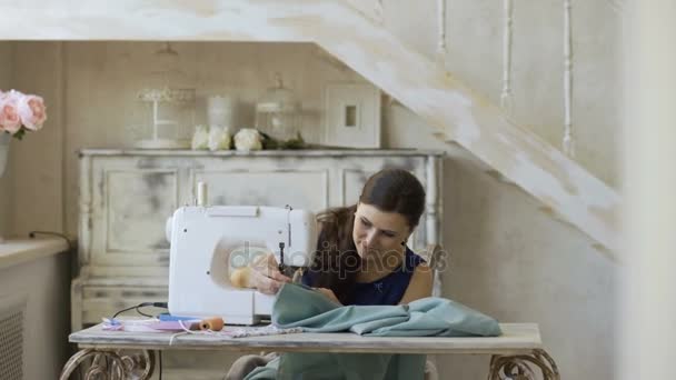 Молодая дизайнер одежды и швея женщина работает с швейной машинкой в портной студии — стоковое видео