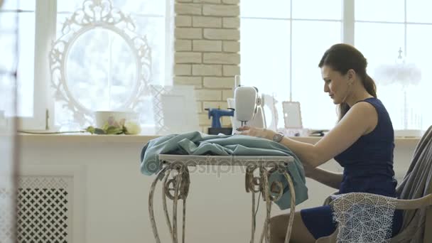 Young clothing designer and seamstress woman work with sewing machine in tailor studio — Stock Video