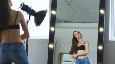 Profesyonel moda modeli üstsüz poz ve makyaj aynaya bakıyor.